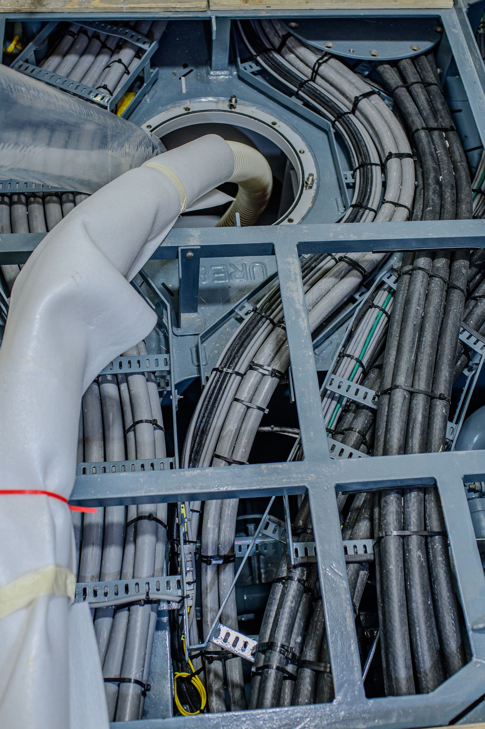 Wind turbine tower base cable transit with heavy marine cables entering a multi-cable transit through a protective sleeve