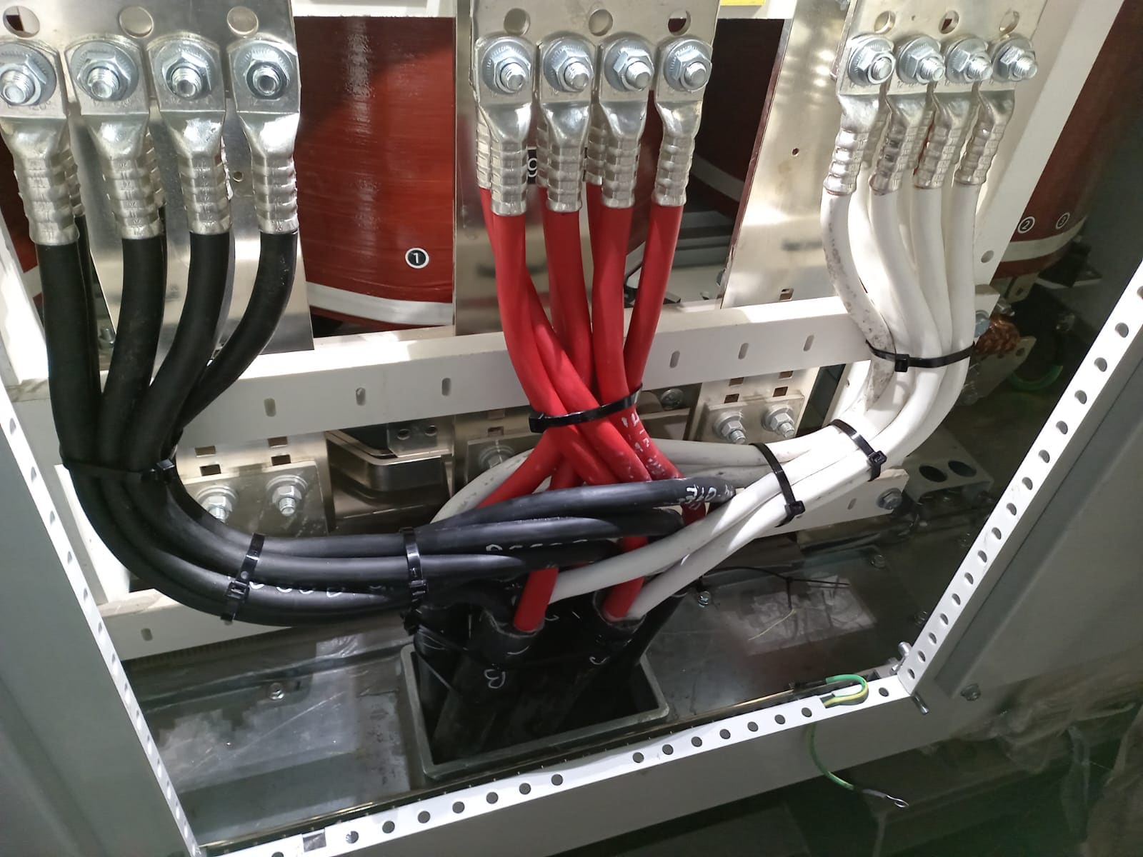 Marine switchboard incoming termination with three sets of red, black and white single-core cables landed on busbar connectors via compression lugs