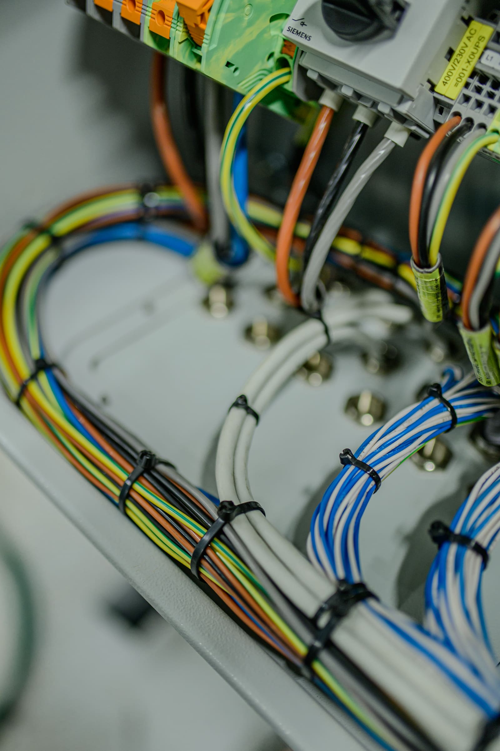 Detail of marine control cables with green-blue, brown, and white conductors fanned out and terminated to a Siemens controller