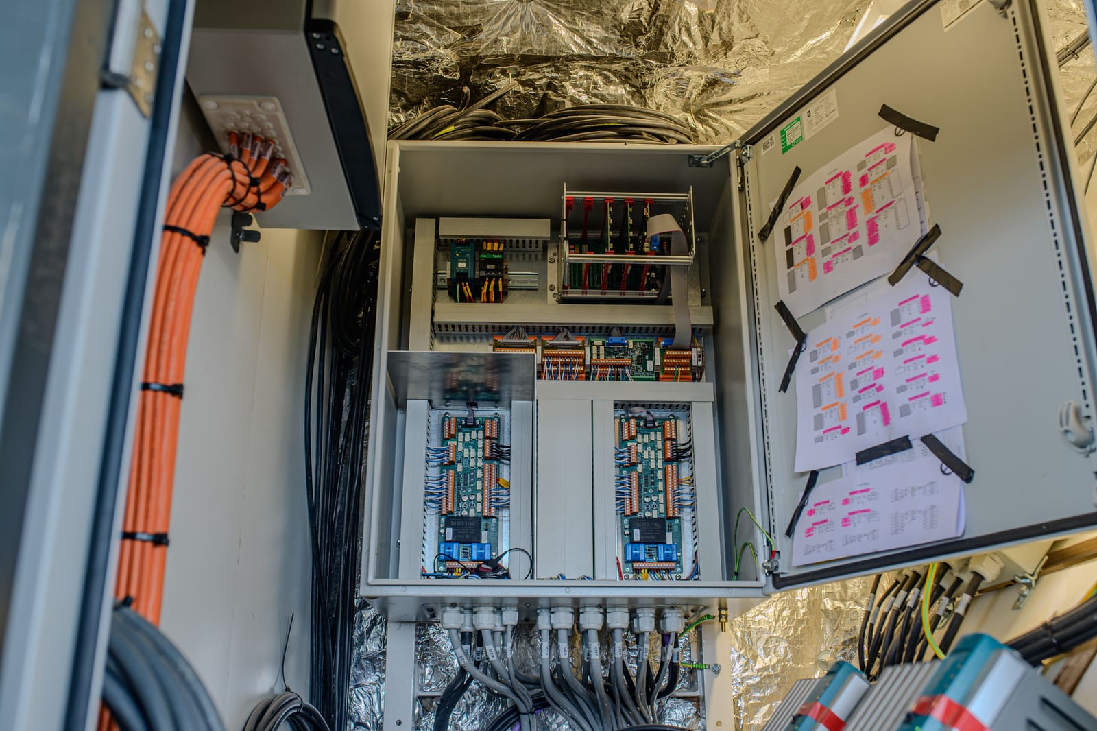 Navigation and automation cabinet bottom view with terminated control cables, terminal racks, and stowed cable bundles awaiting commissioning