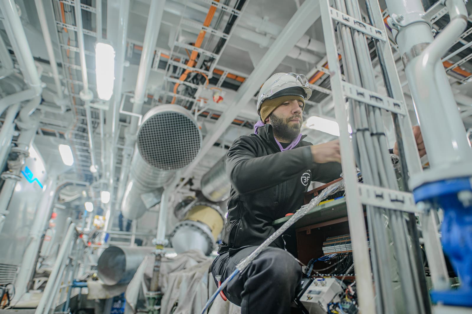 Close-up of a technician terminating a marine electrical cable inside a switchboard.