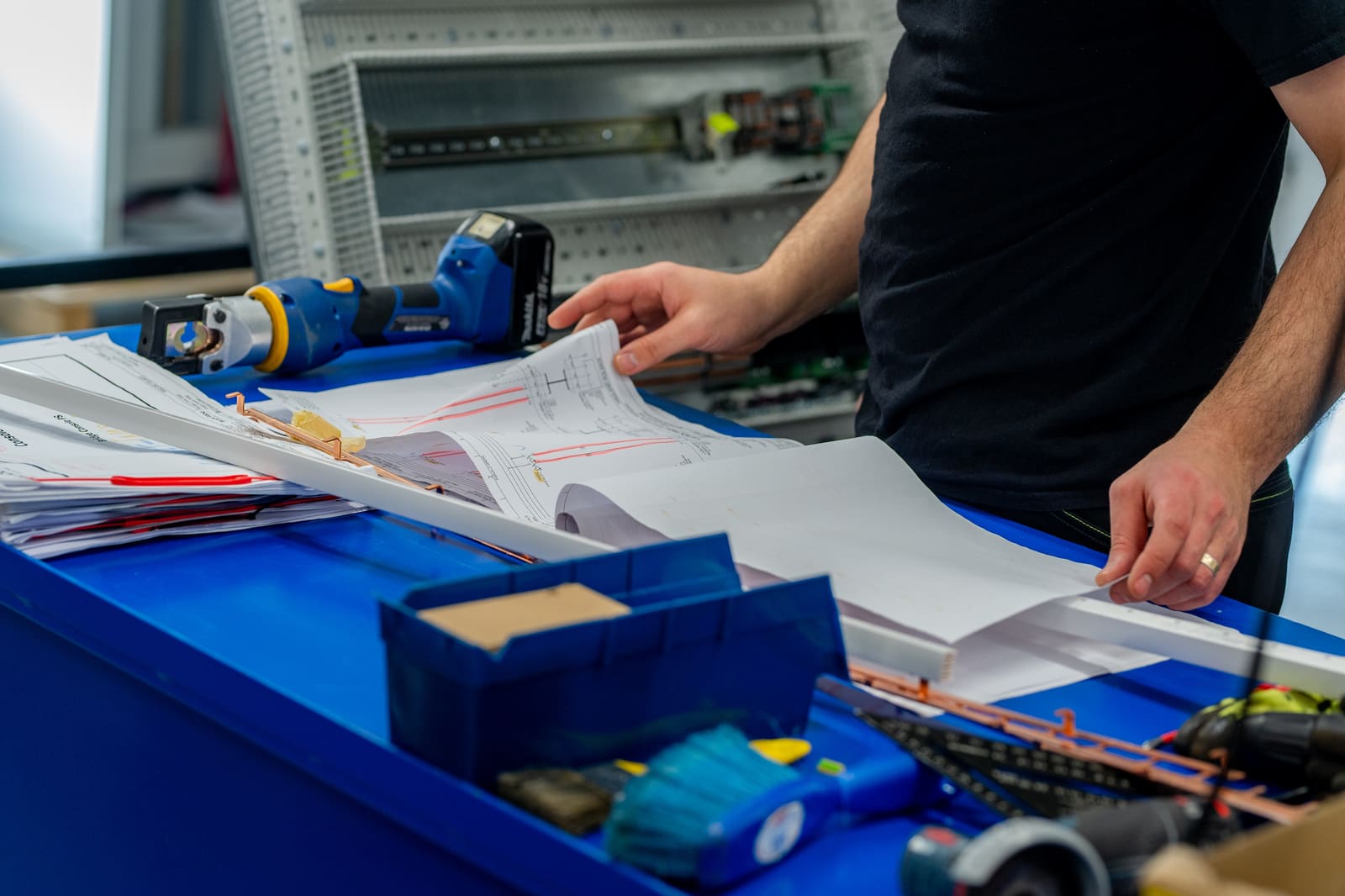 Panel builder reviewing electrical schematics at the workbench during a control panel build
