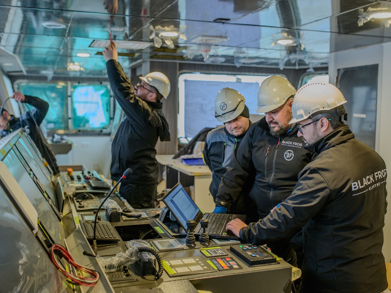 Engineers commissioning a marine electrical system at the main switchboard.
