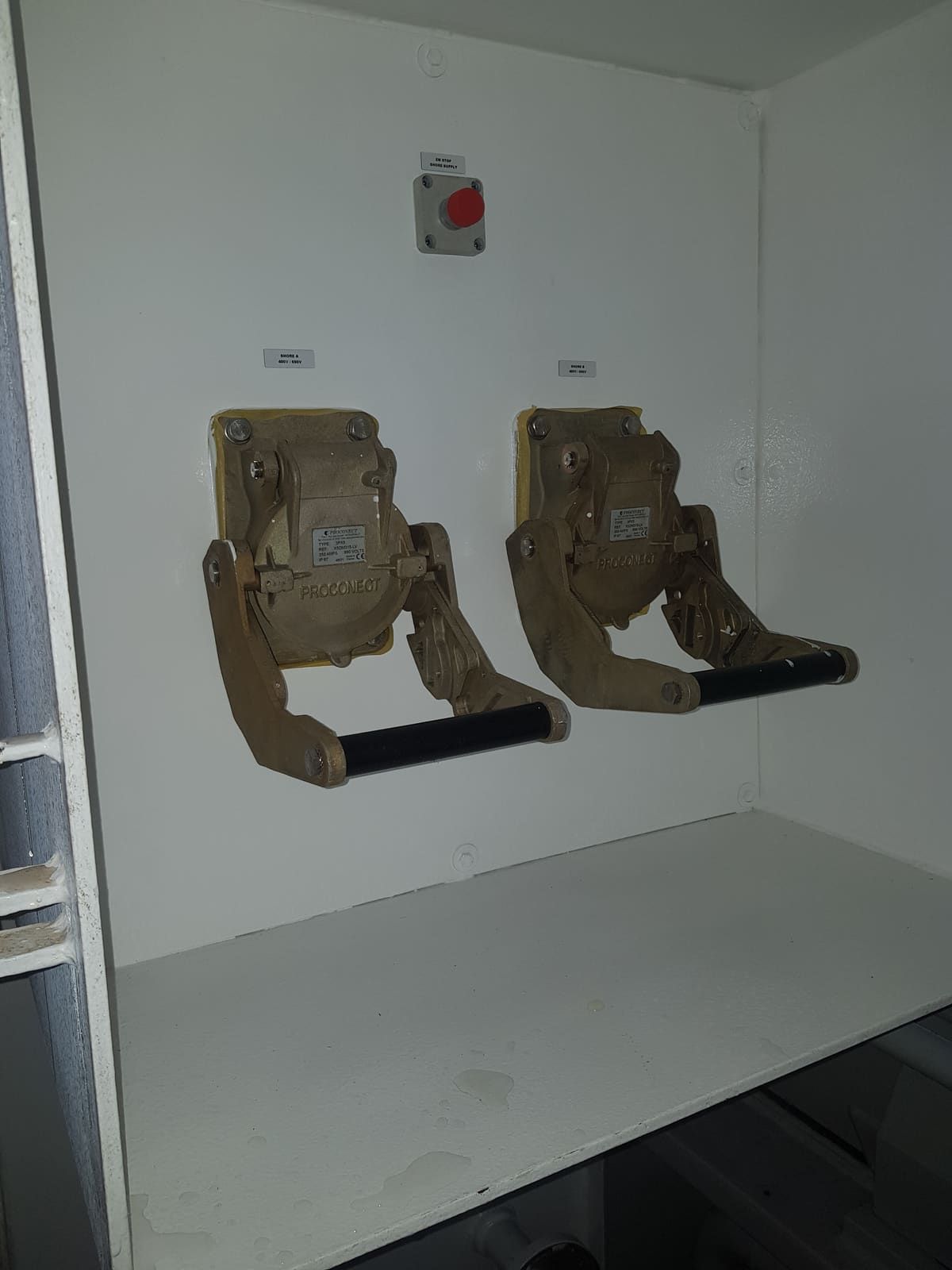 Two heavy bronze quick-closing fuel valves mounted on a control station bulkhead with a remote pushbutton