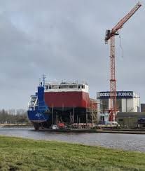 RB 5800 Eco Trader multipurpose cargo vessel under construction at the Bodewes Foxhol quay with a tall red gantry crane in the background.